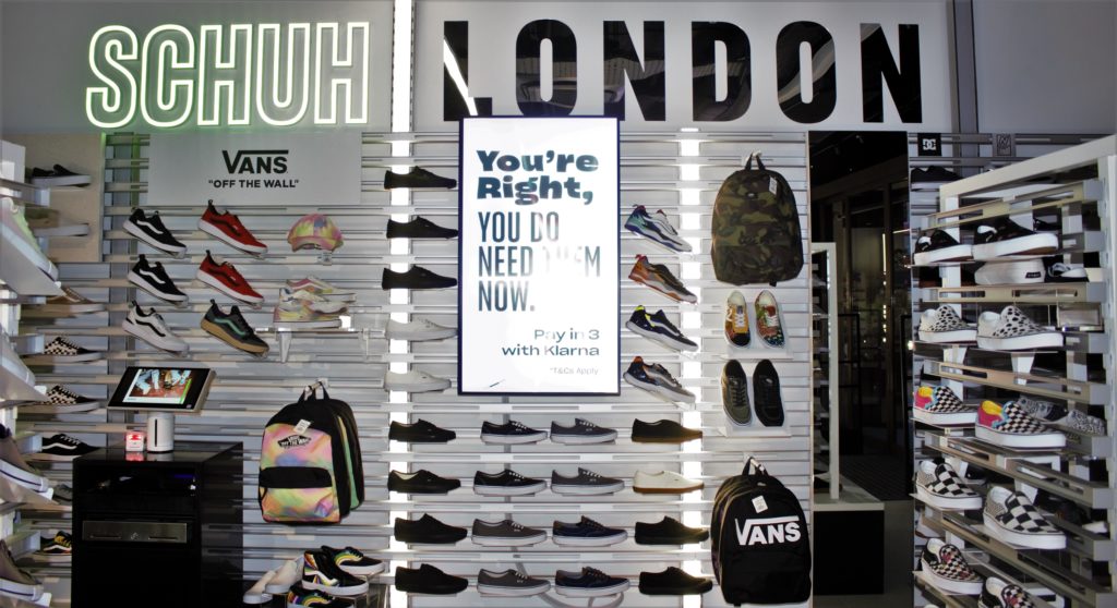 Inside a Schuh Store, brightly lit with rows and rows of shoes on sales